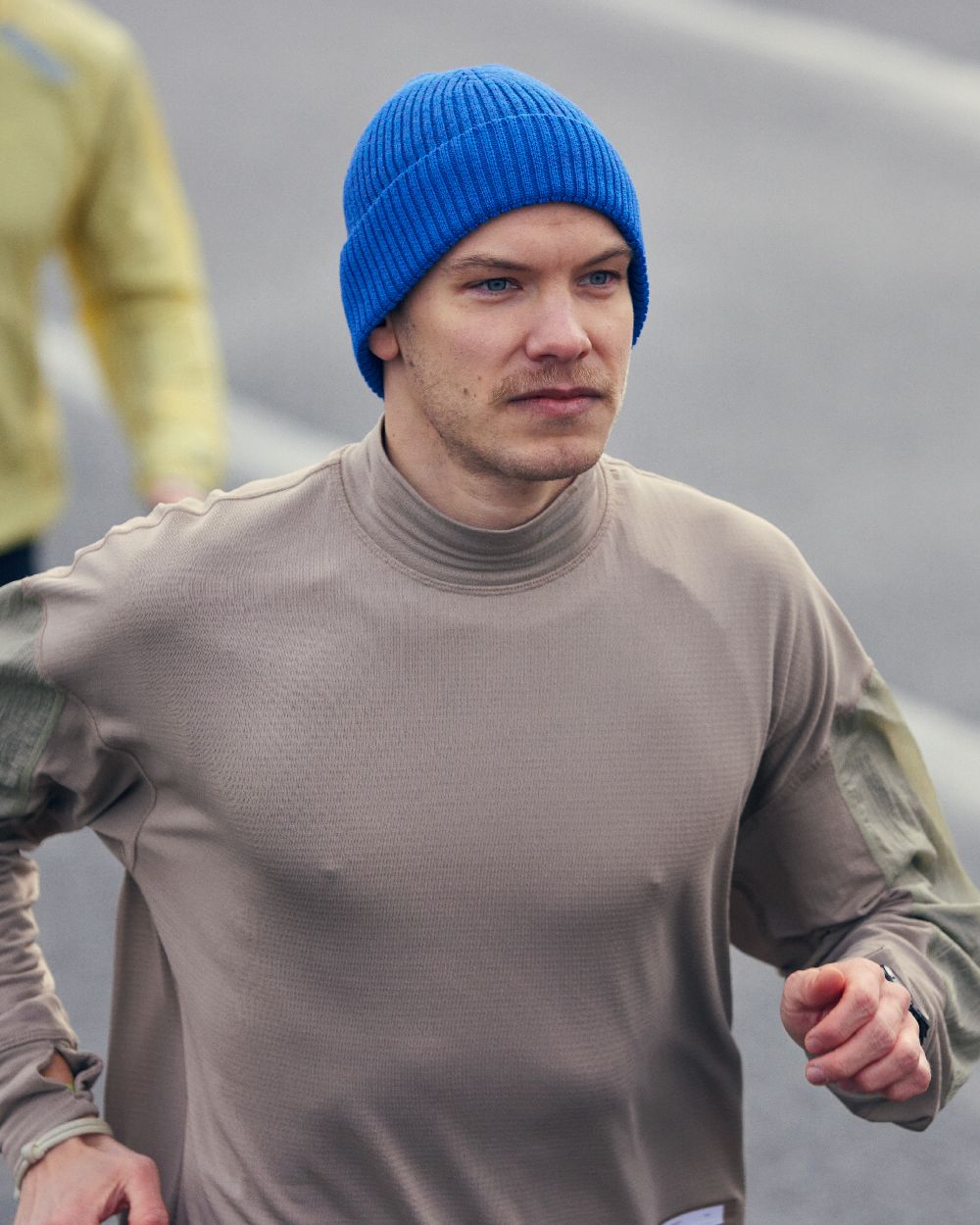 Cobalt Coloured Buff Merino Active Beanie on blurry background 