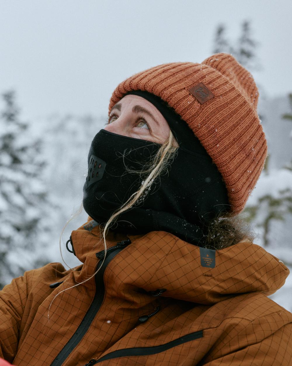 Black Coloured Buff Merino Lightweight Balaclava on snow background 