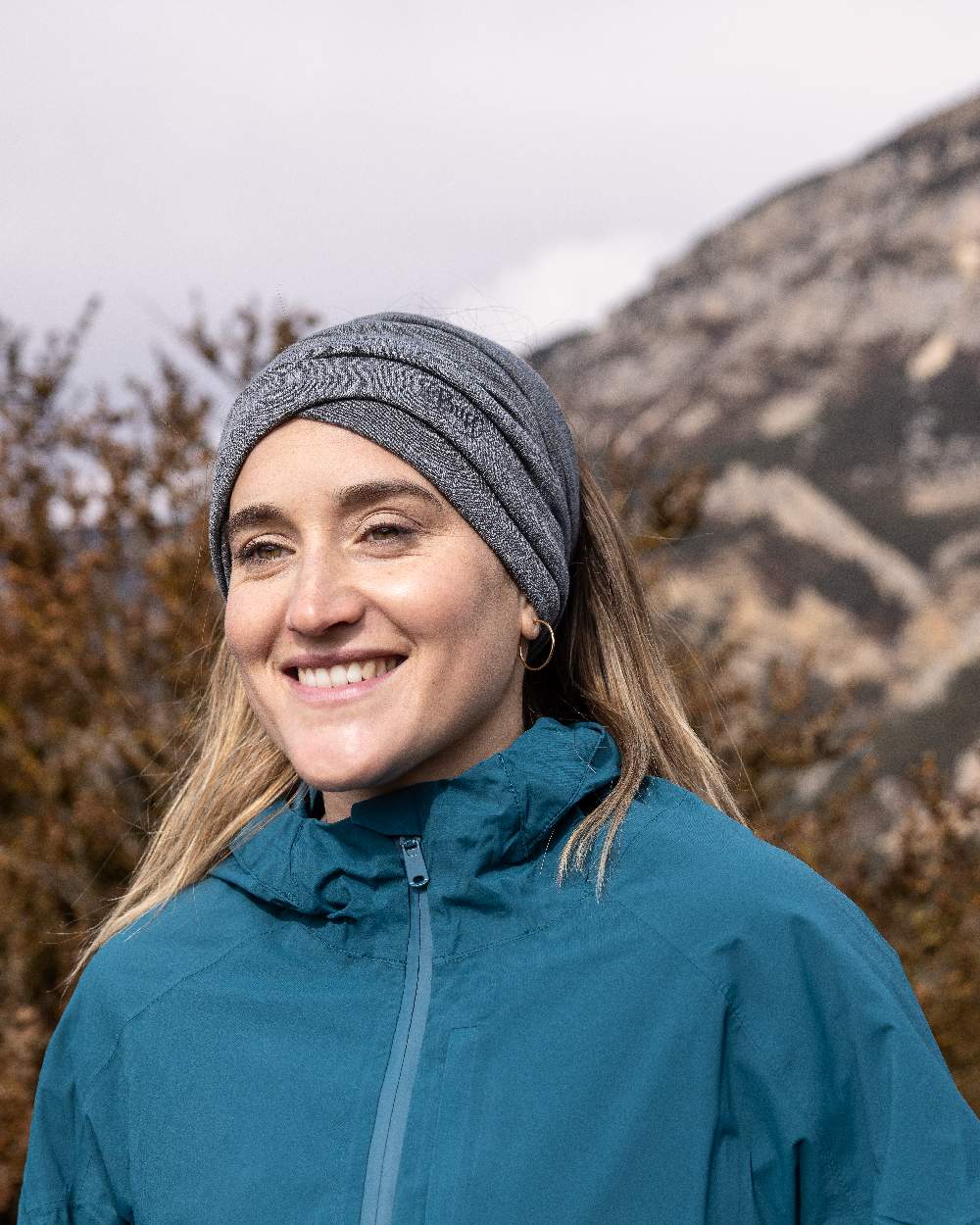 Light Grey Coloured Buff Merino Lightweight Neck Warmer on mountain background 
