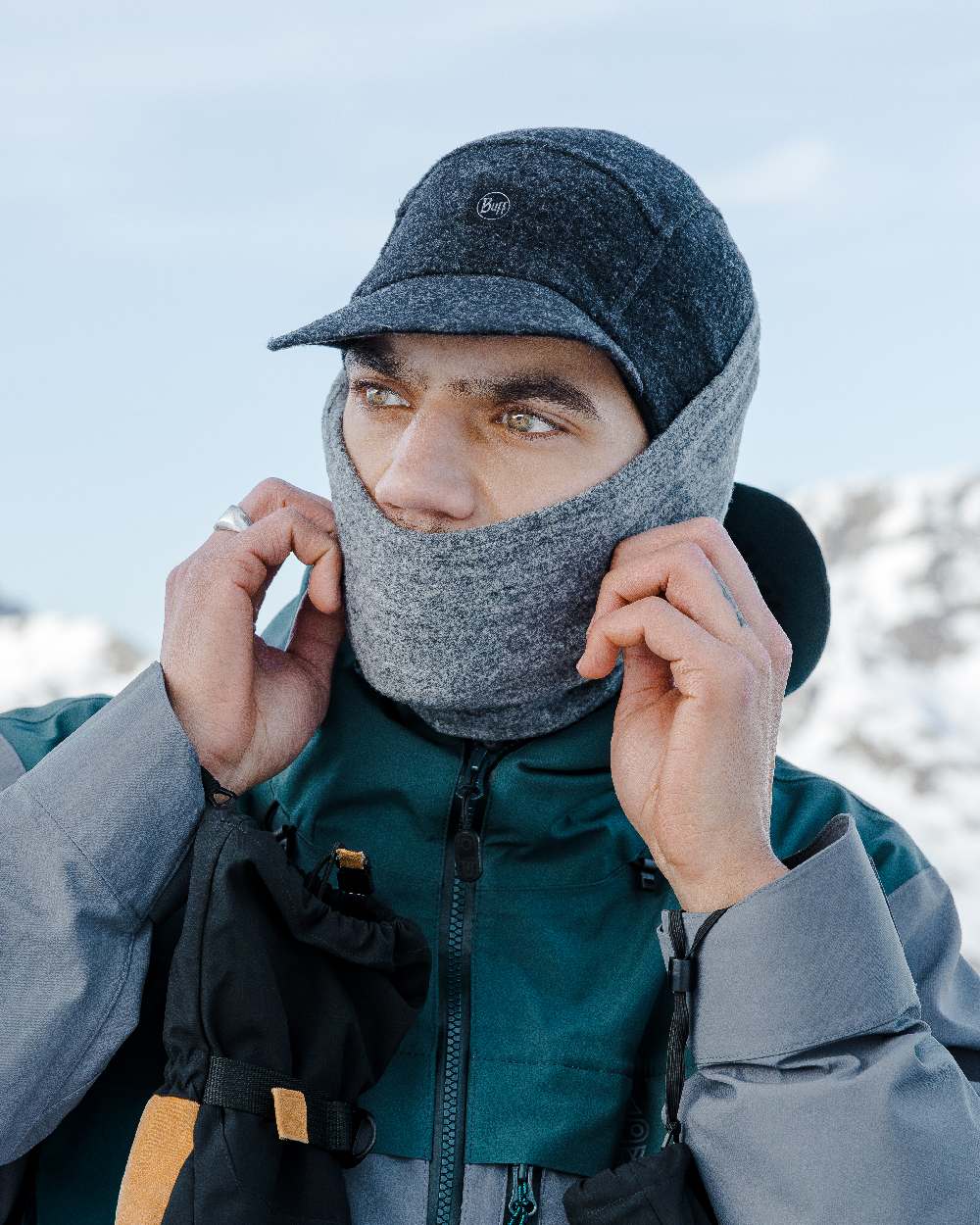 Black Coloured Buff Pack Merino Fleece Cap on snow background 