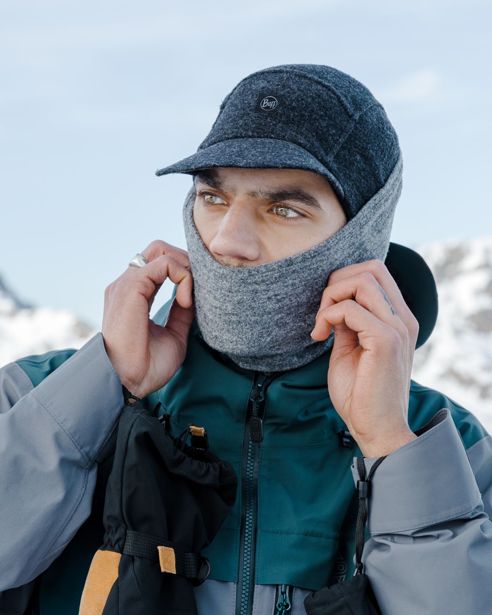 Grey Coloured Buff Pack Merino Fleece Cap on snow background 