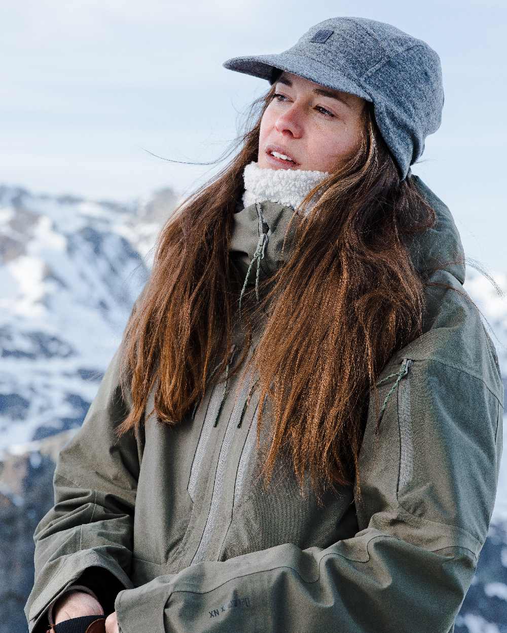 Grey Coloured Buff Pack Merino Fleece Cap on snow background 