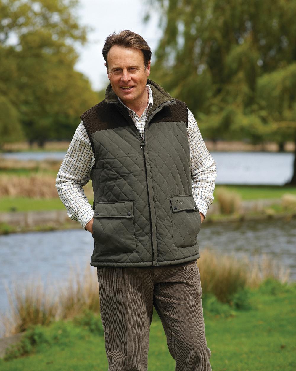 Olive coloured Champion Arundel Diamond Quilted Bodywarmer on blurry lake background 