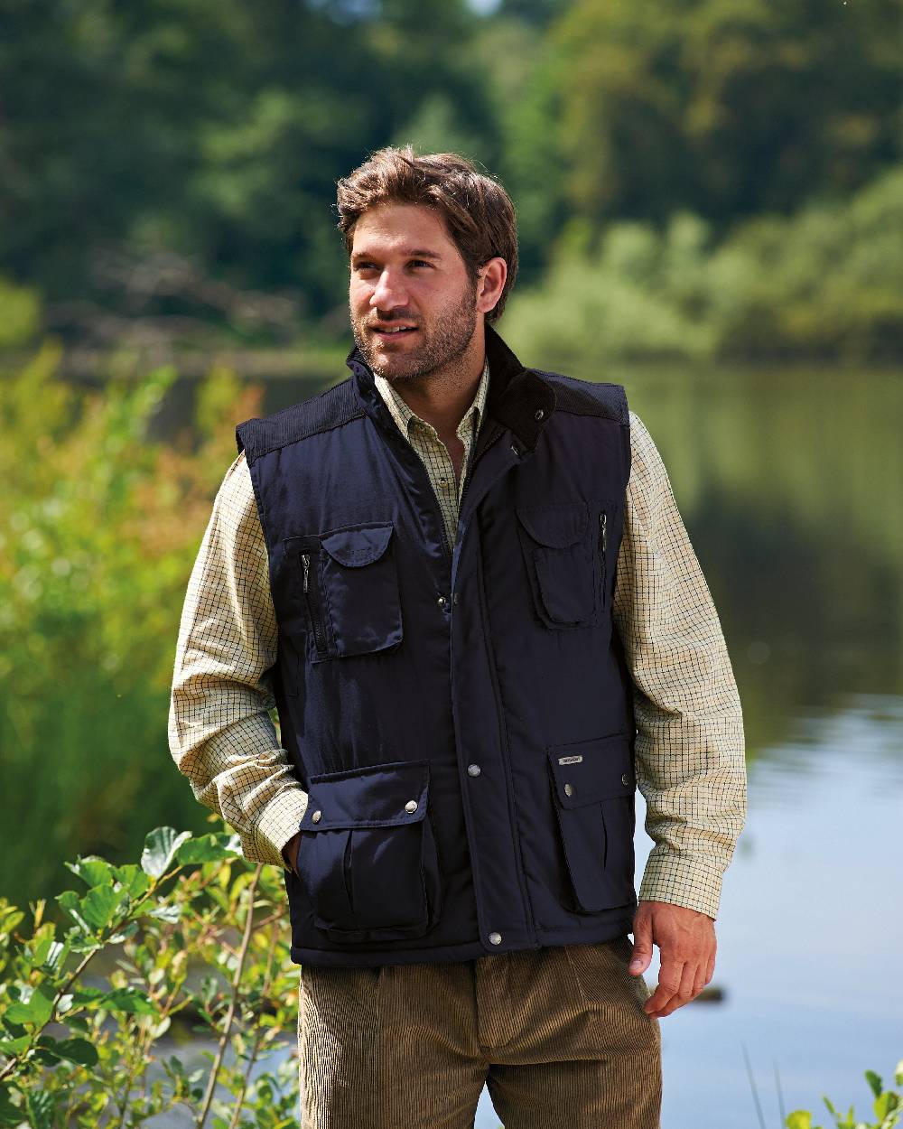 Navy coloured Champion Exmoor Multi Pocket Padded Bodywarmer on river background 