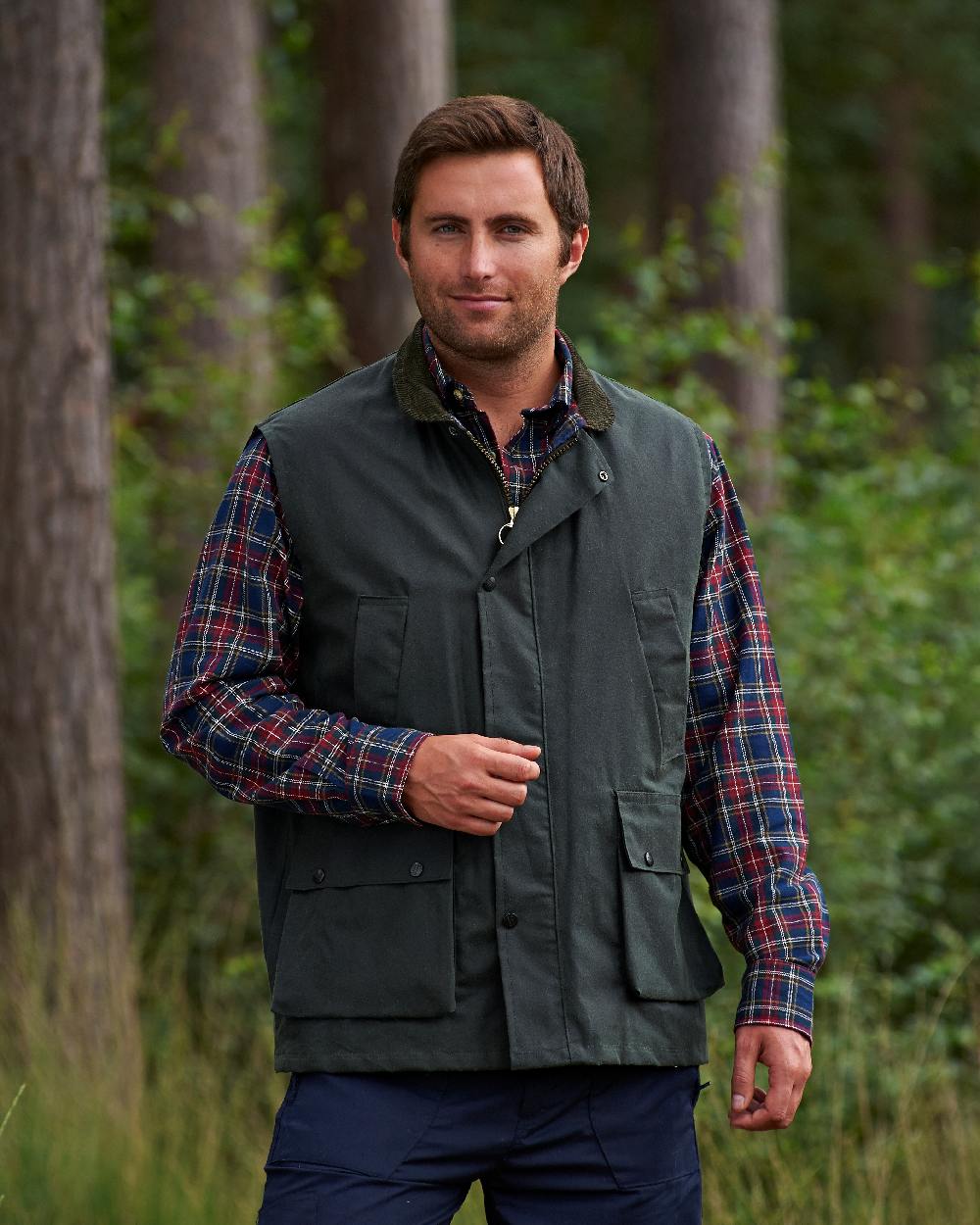 Green coloured Champion Lanark Waxed Cotton Waistcoat on forest background 