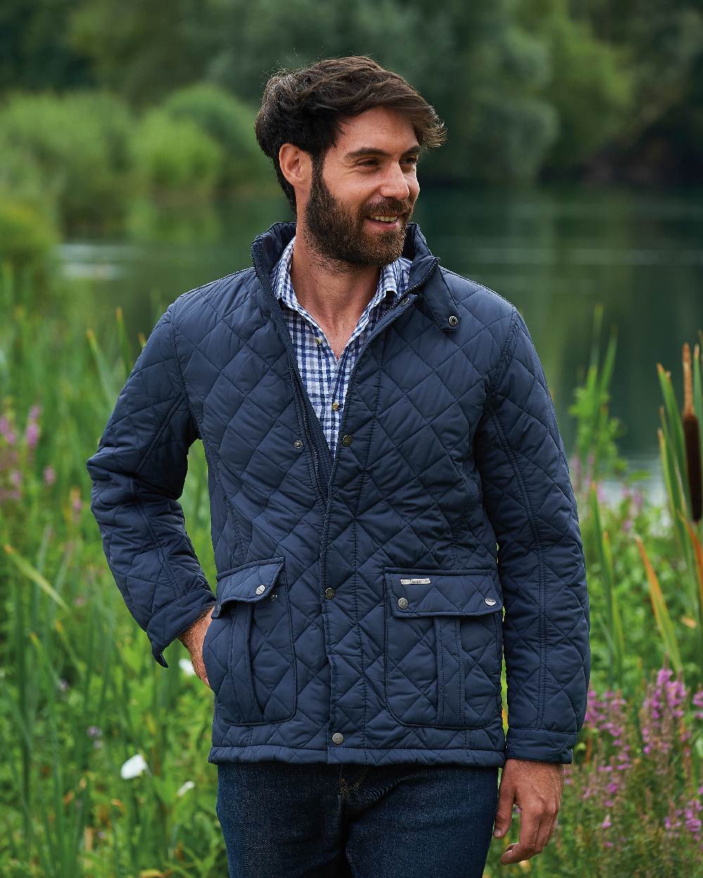 Navy coloured Champion Padstow Quilted Jacket on pond background 