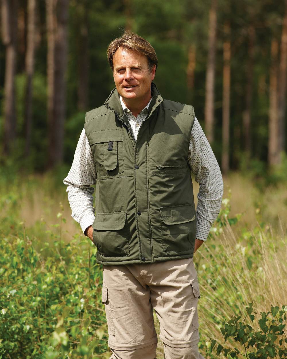 Olive coloured Champion Peak Multi-Pocket Padded Bodywarmer on forest background 