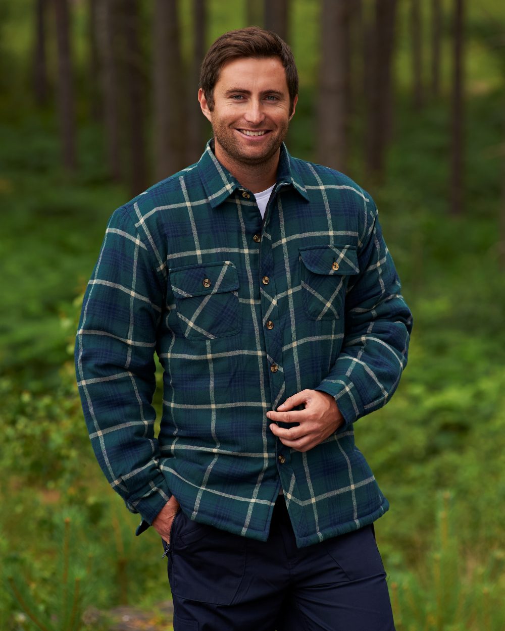 Green coloured Champion Totnes Quilted Padded Shirt on forest background 