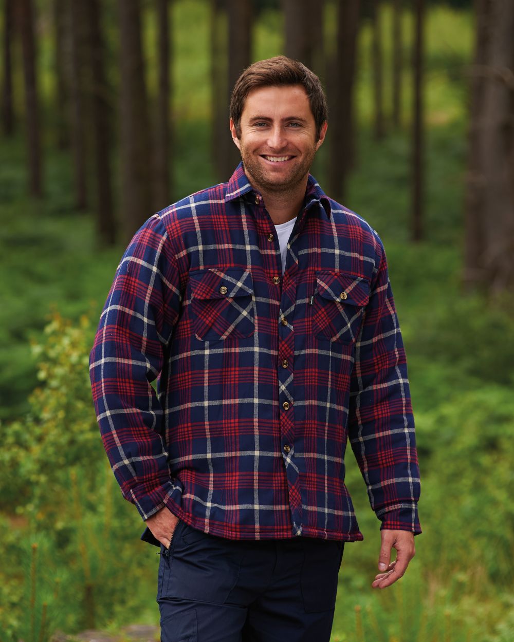 Red coloured Champion Totnes Quilted Padded Shirt on forest background 