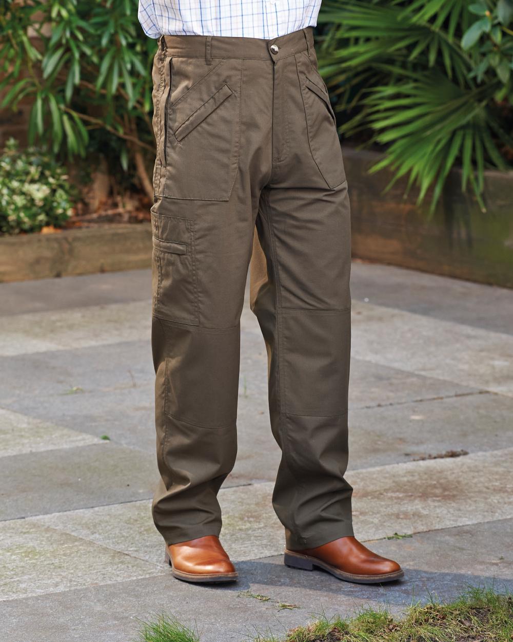 Olive coloured Champion Wenlock Multi Pocket Activity Trousers on backyard background 