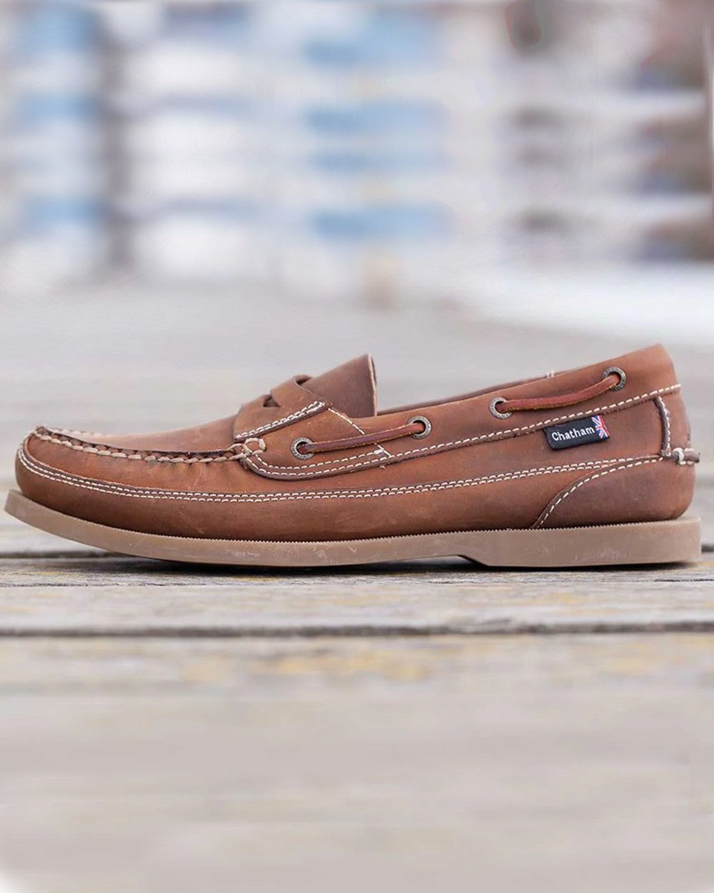 Walnut Coloured Chatham Mens Gaff II G2 Slip On Leather Boat Shoes on blurry background 