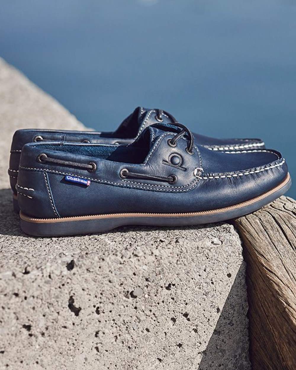 Navy coloured Chatham Mens Whitstable Premium Leather Boat Shoes on sea background 