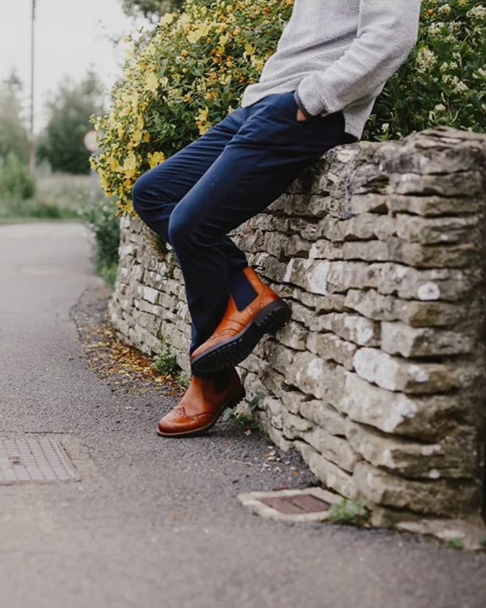 Tan coloured Cotswold Cirencester Chelsea Brogues with wall in background 