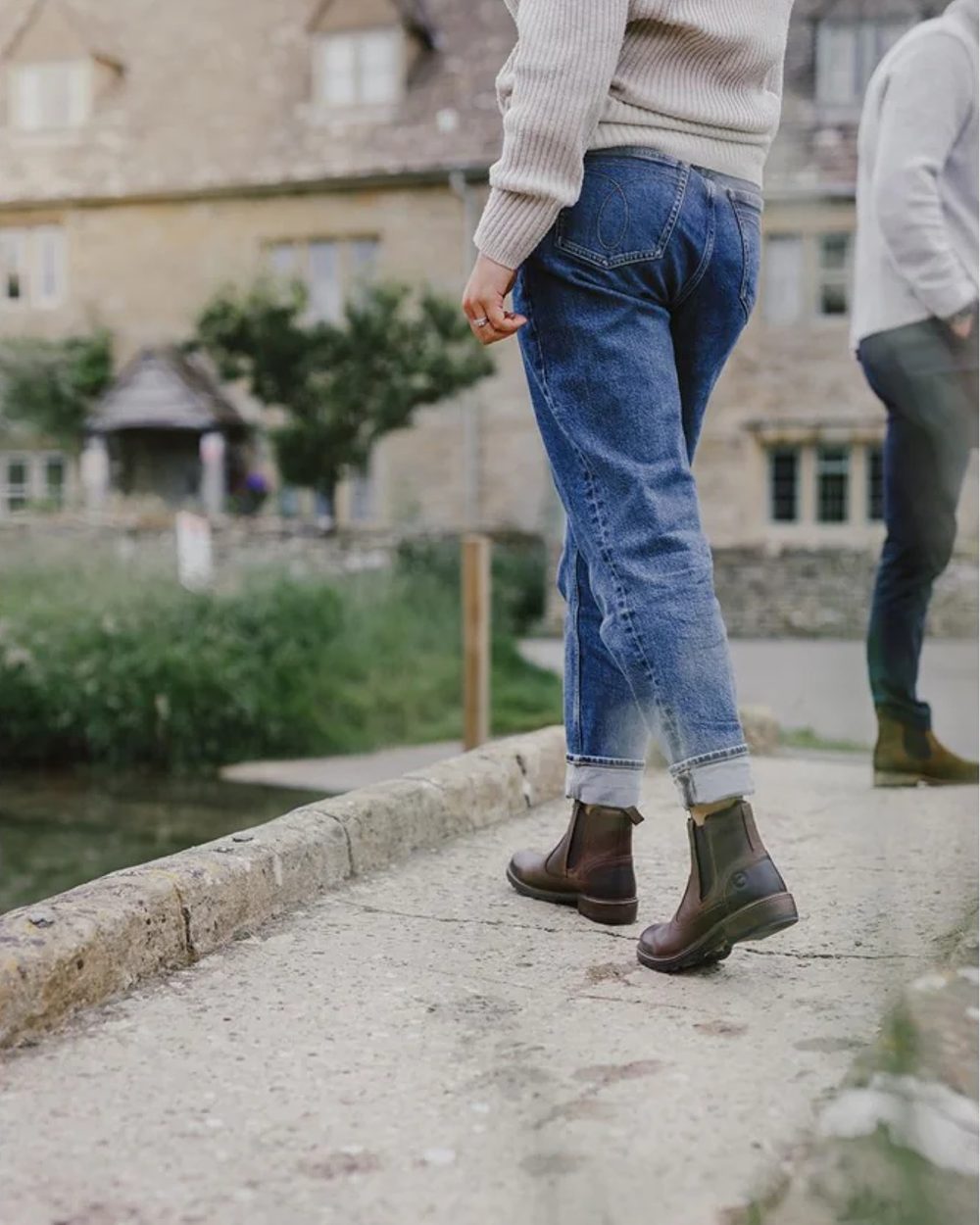 Brown coloured Cotswold Womens Laverton Ankle Boots on blurry path background 