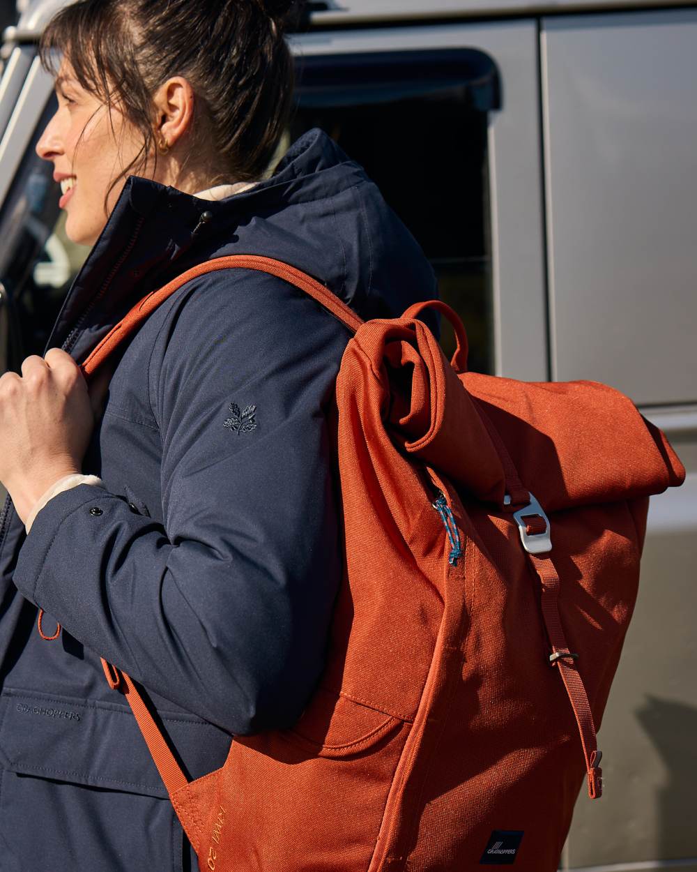 Red Beach coloured Craghoppers 20L Kiwi Classic Rolltop Backpack II on outdoor background 