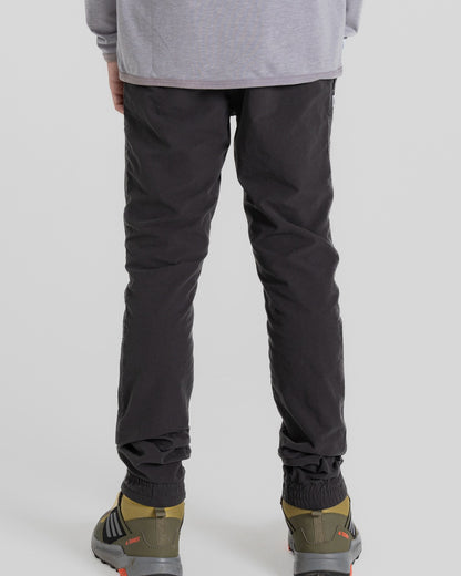 Black Pepper Coloured Craghoppers Kids Nosilife Pinzon Trousers on Beige Background 