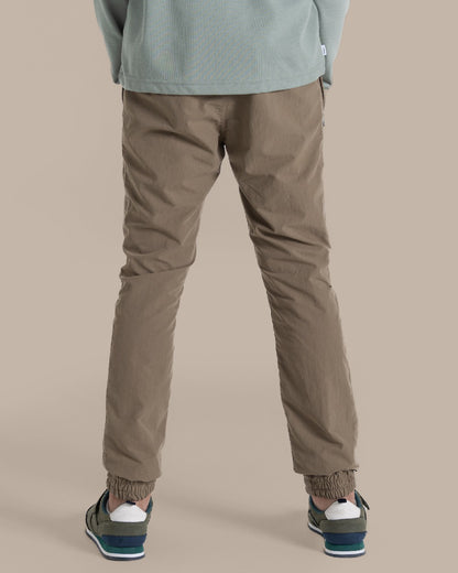 Pebble Coloured Craghoppers Kids Nosilife Pinzon Trousers on Beige Background 