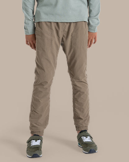 Pebble Coloured Craghoppers Kids Nosilife Pinzon Trousers on Beige Background 