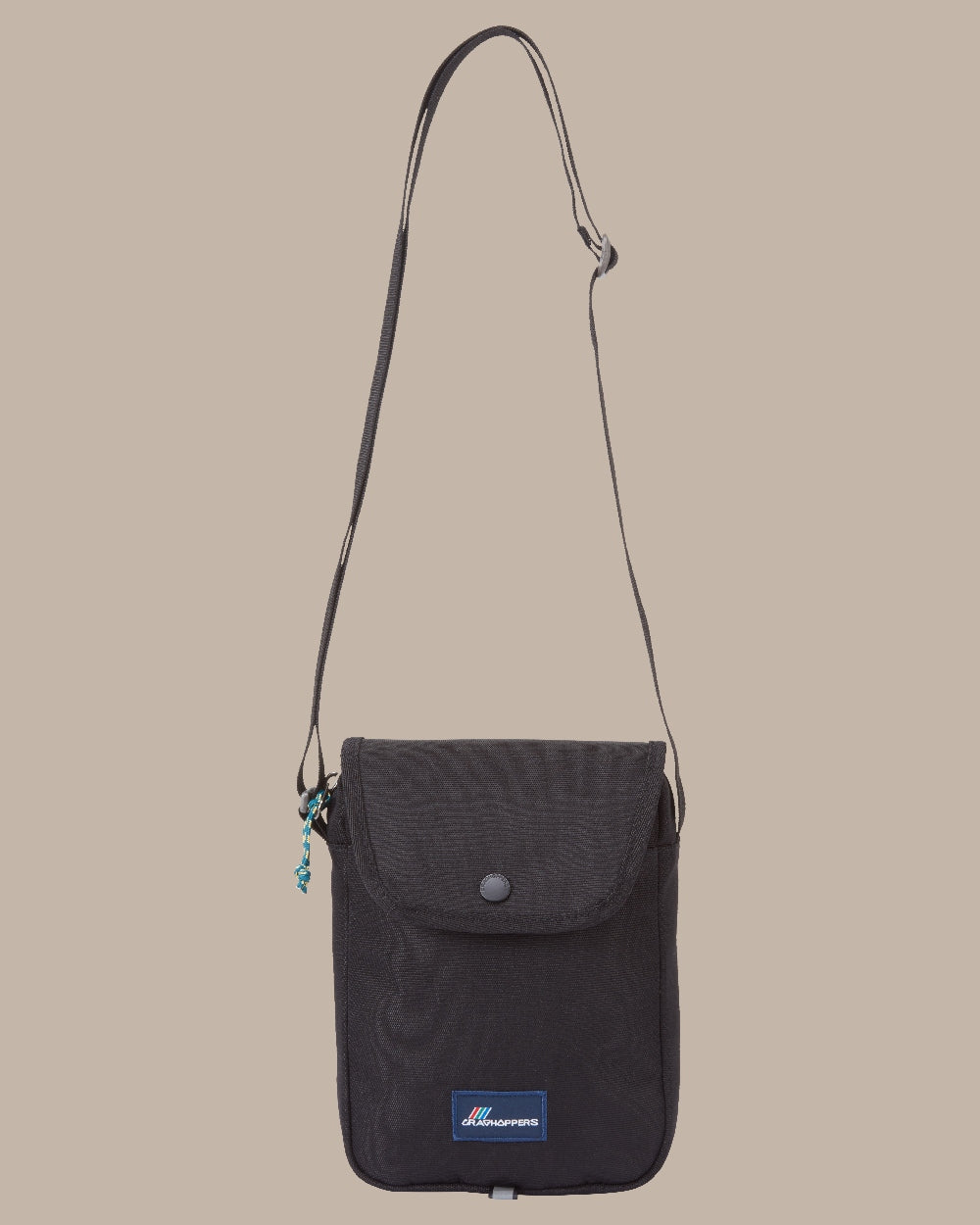 Black Coloured Craghoppers Kiwi Crossbody II on Beige Background 