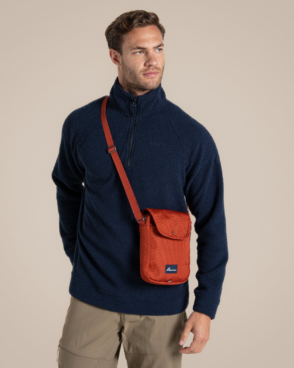 Red Beach Coloured Craghoppers Kiwi Crossbody II on Beige Background 