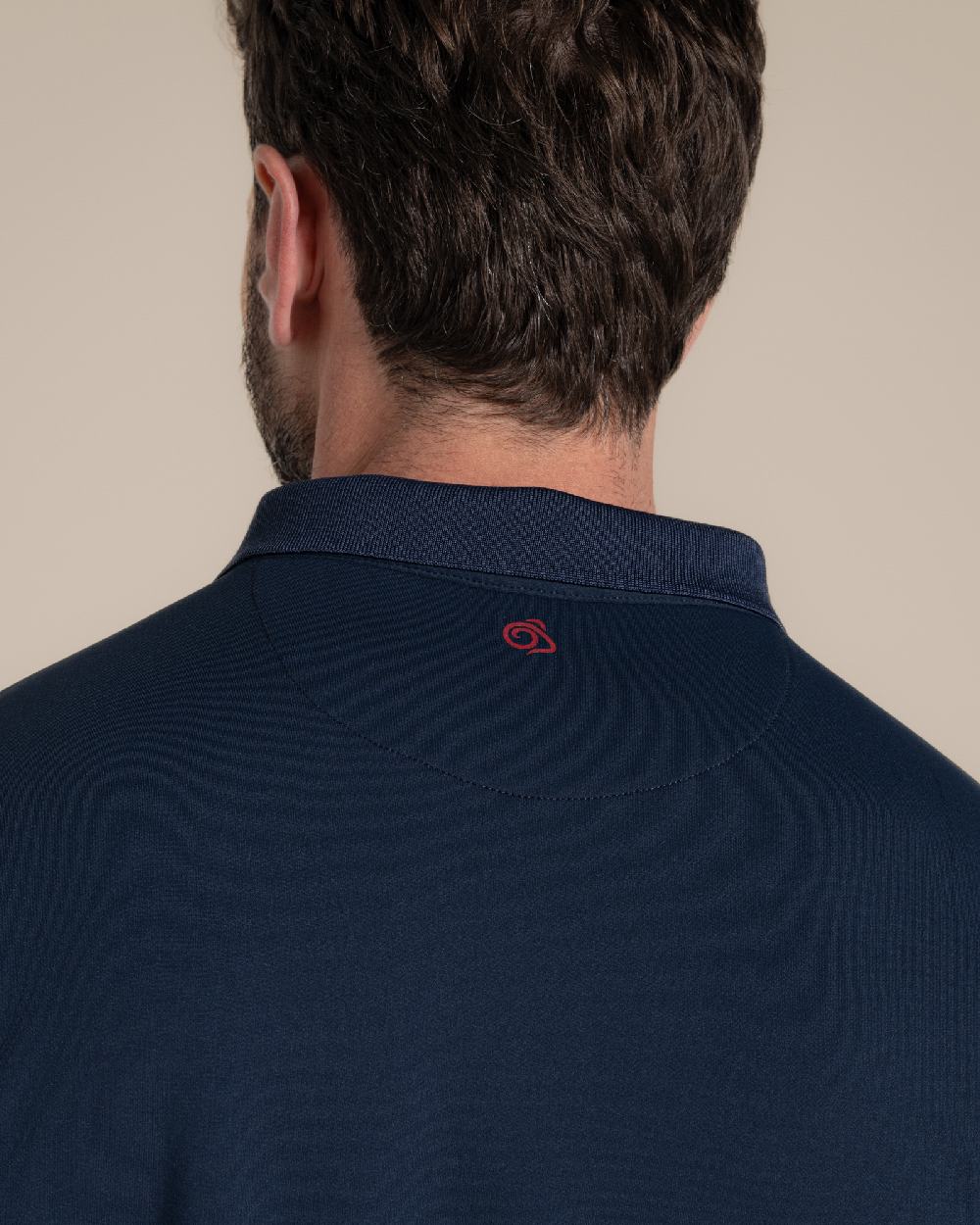 Blue Navy Coloured Craghoppers Mens Nosilife Bramshaw Short Sleeved Polo Top on Beige Background 