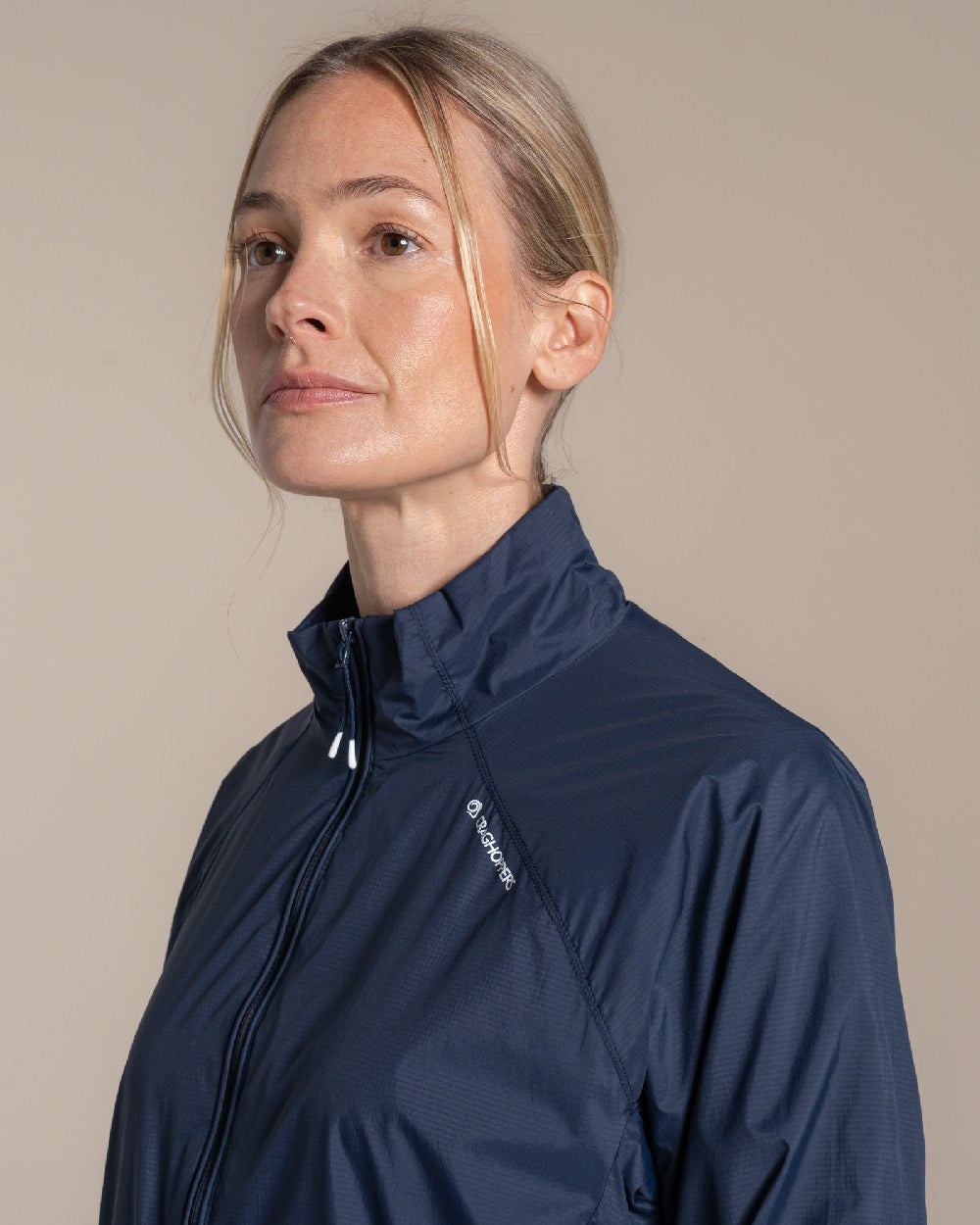 Blue Navy Coloured Craghoppers Womens Nosilife Driver Jacket on Beige Background 