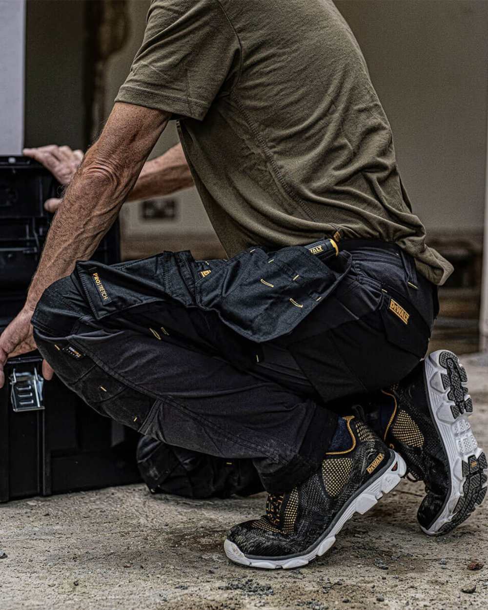 Grey coloured DeWalt Memphis Regular Fit Stretch Trousers on outdoor background 