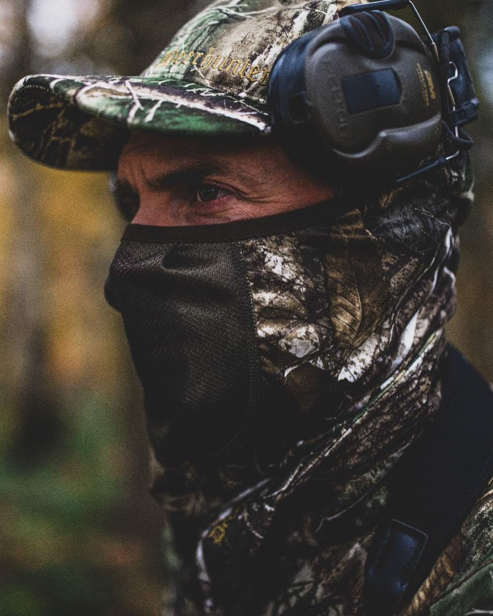 Realtree Adapt coloured Deerhunter Approach Face Mask on blurry background