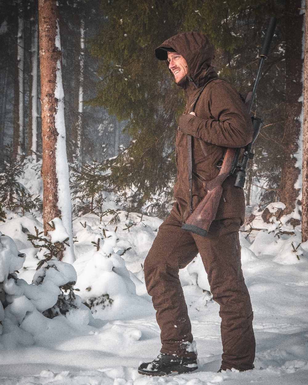 Art Green coloured Deerhunter Excape Winter Waterproof Trousers on snow background 