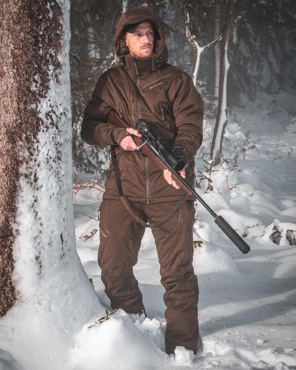 Art Green coloured Deerhunter Excape Winter Waterproof Trousers on snow background 