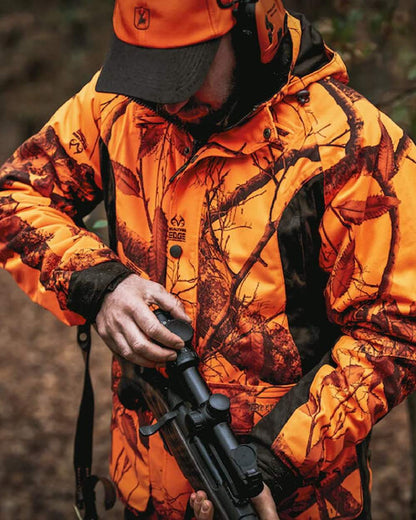 Realtree Edge Orange Coloured Deerhunter Explore Jacket on blurry background 