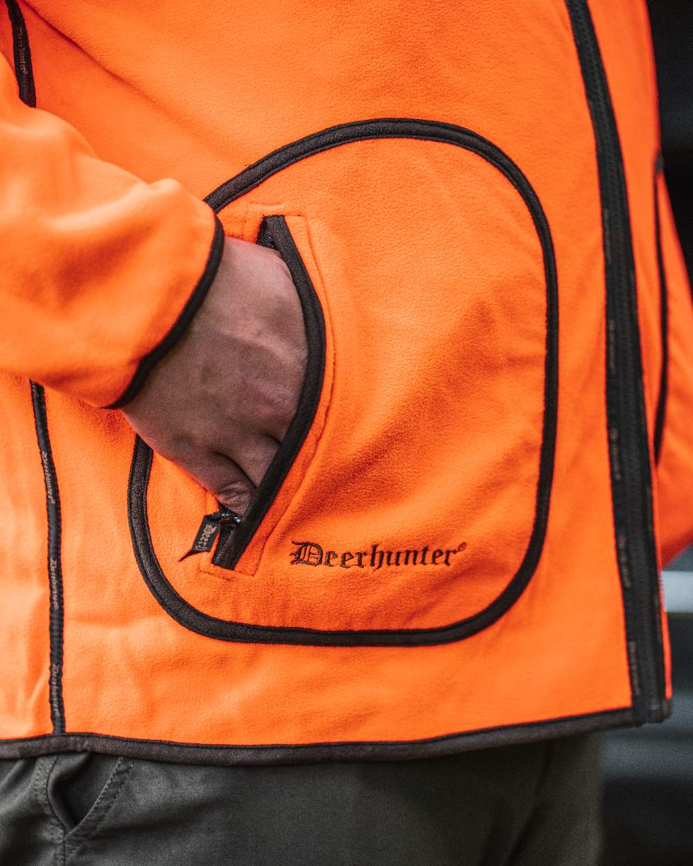 Canteen Orange coloured Deerhunter Gamekeeper Reversible Bonded Fleece Jacket on blurry background 