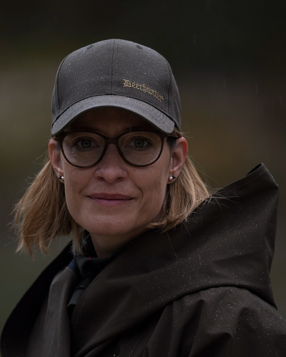 Canteen Coloured Deerhunter Ladies Waterproof Rain Poncho on blurry background 