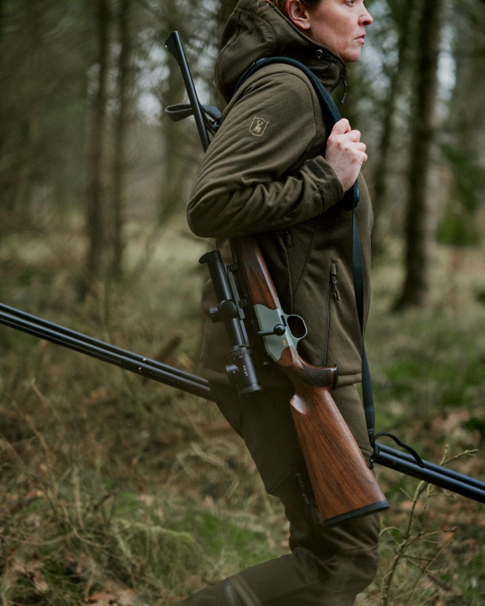 Art Green coloured Deerhunter Lady Excape Softshell Trousers on forest background 