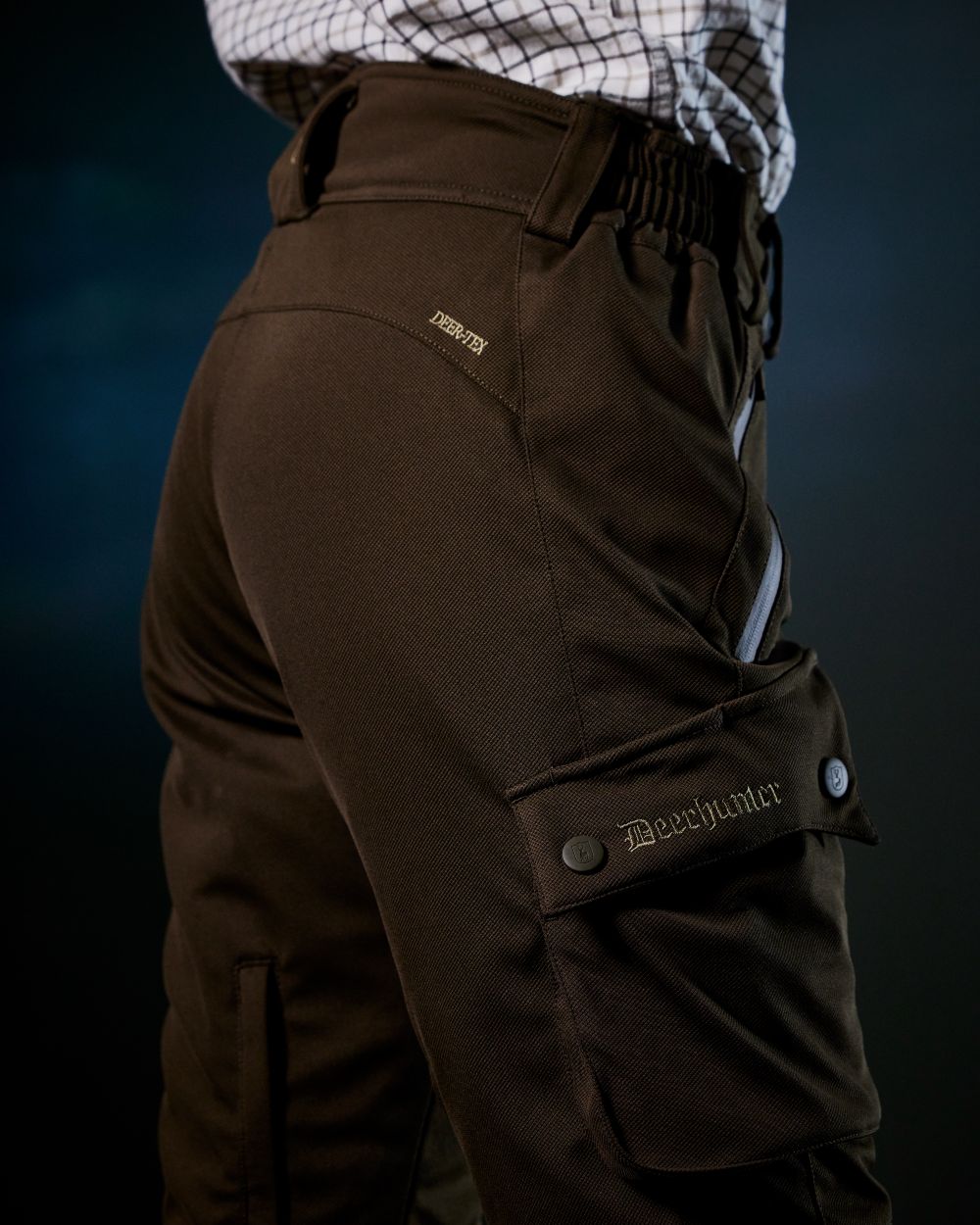 Art Green coloured Deerhunter Lady Muflon Pro Trousers on forest background 