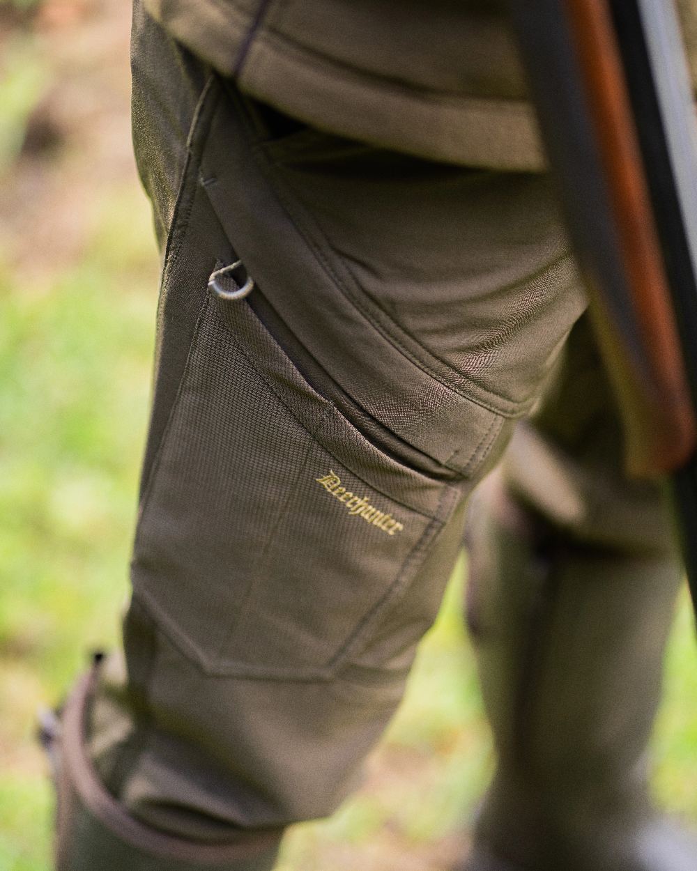 Bark Green coloured Northward Trousers on blurry background 