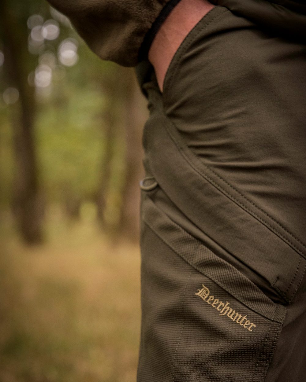 Bark Green coloured Northward Trousers on blurry background 