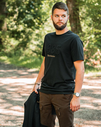 Black coloured Deerhunter Mens Jubilee T-Shirt on forest background 