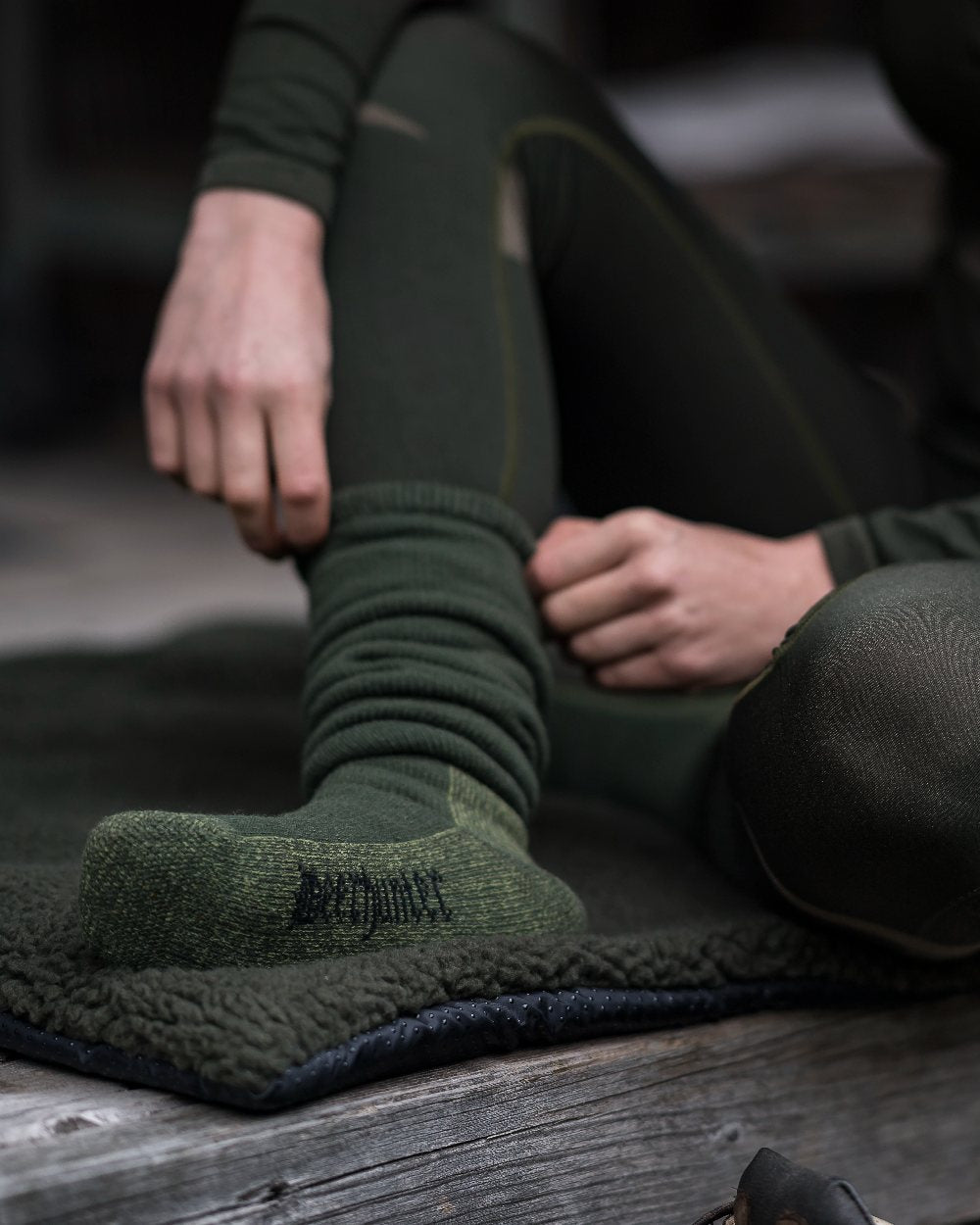 Grape Leaf coloured Deerhunter Wool Socks Deluxe Long on bench background 