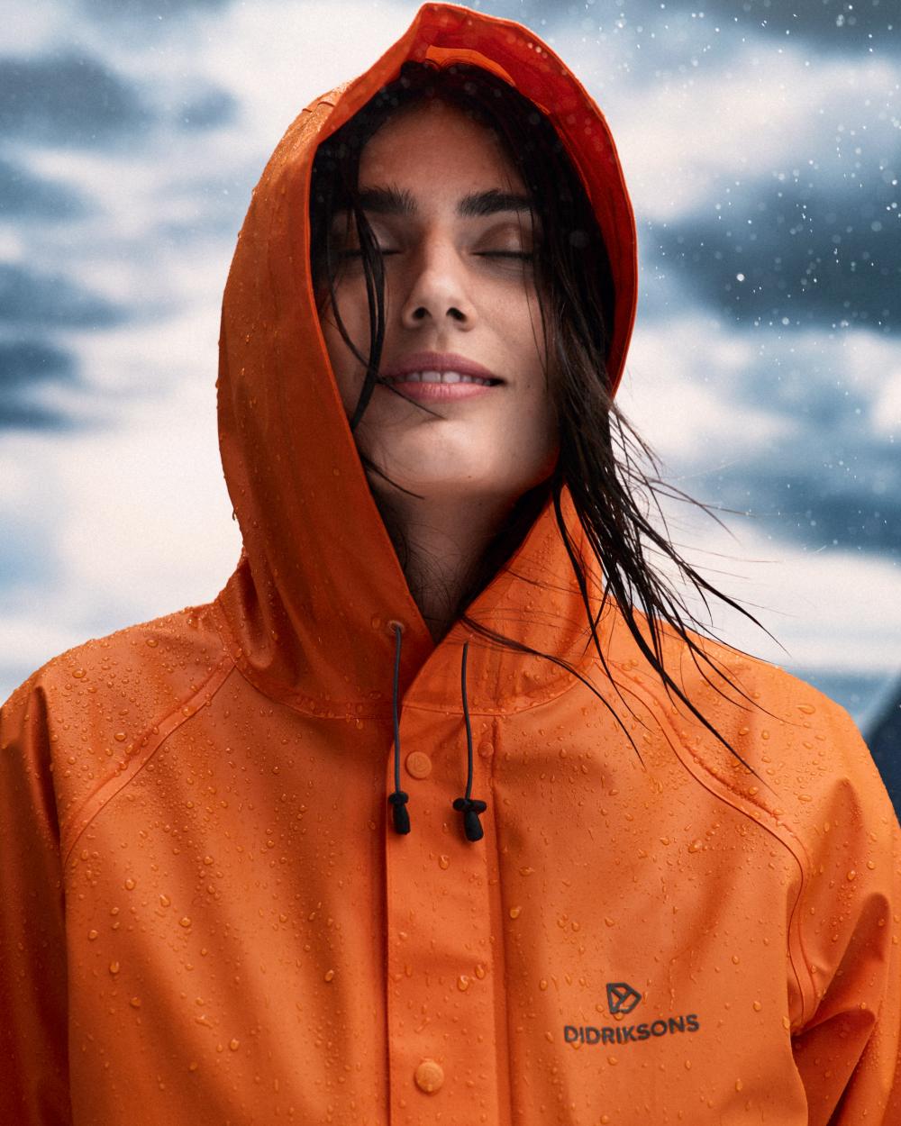 Flame coloured Didriksons Avon Parka on sky background 