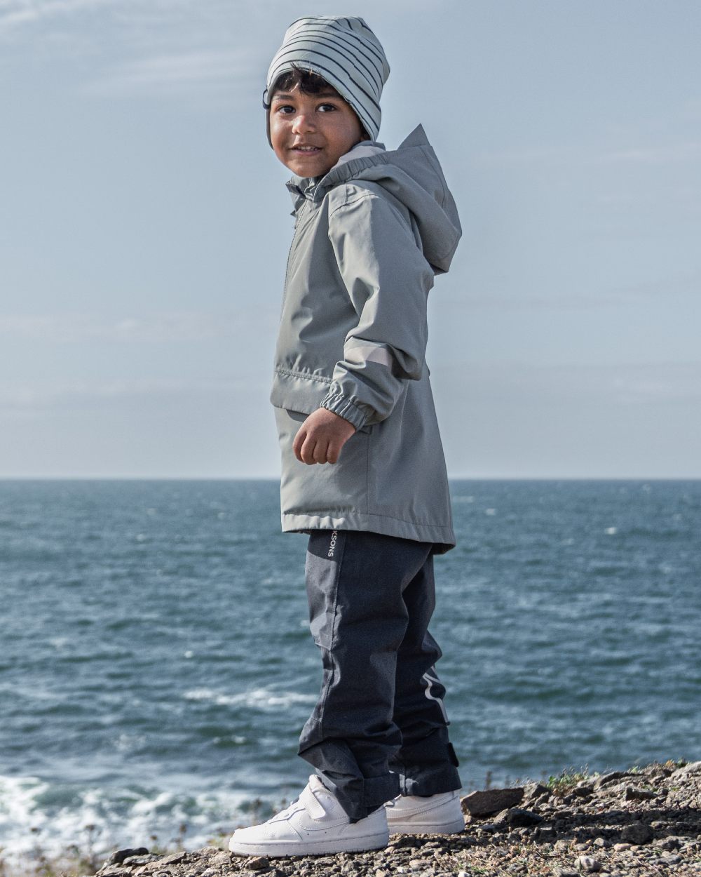 Navy coloured Didriksons Childrens Avan Pants 2 on sea background 