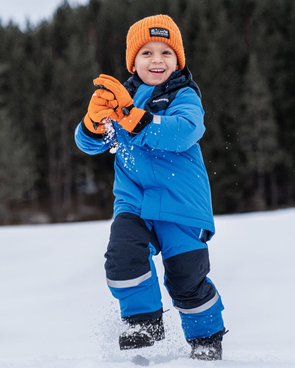 Orange Jam coloured Didriksons Childrens Biggles Gloves on snow background 