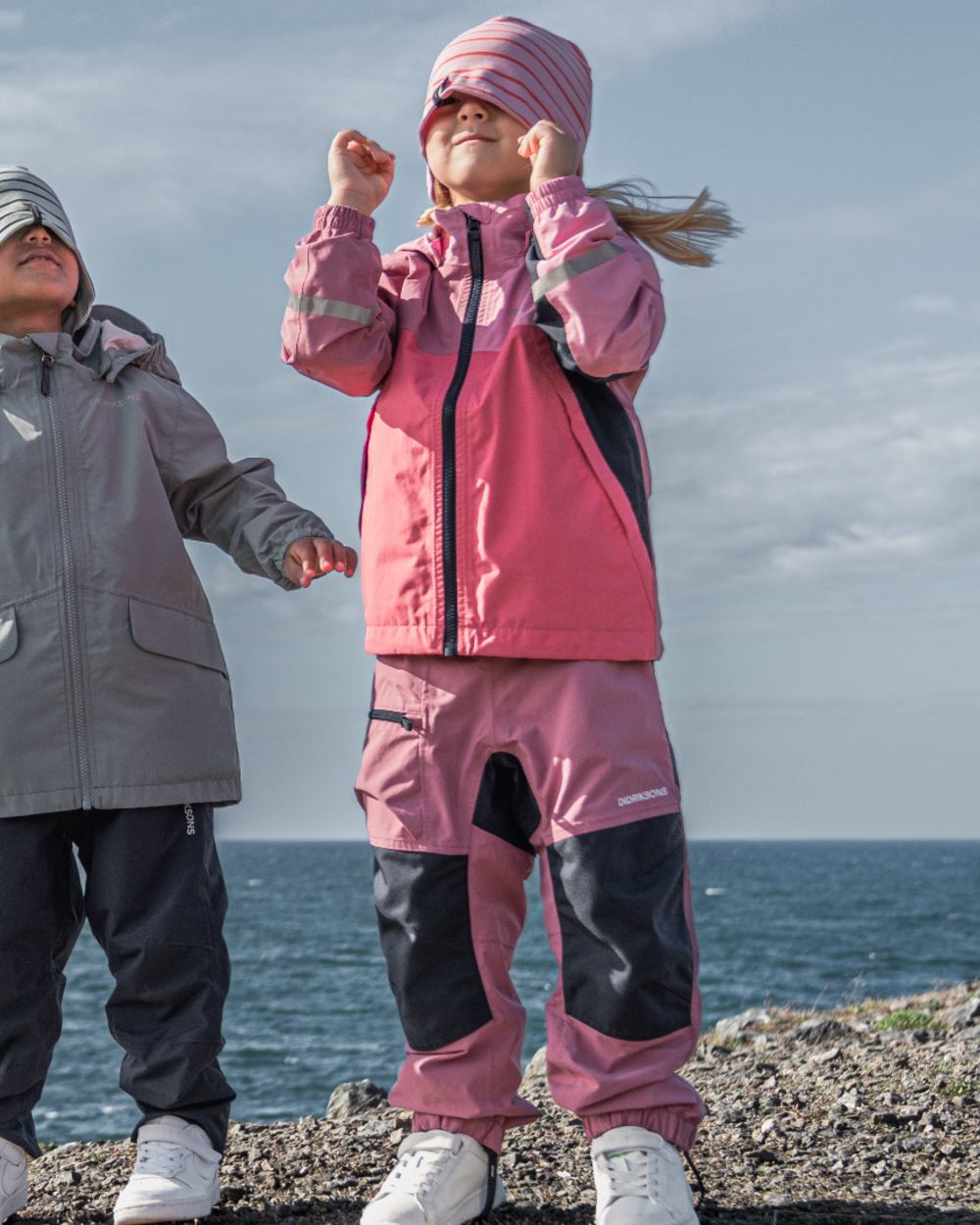 Heather Pink coloured Didriksons Childrens Dusk Pants on sea background 