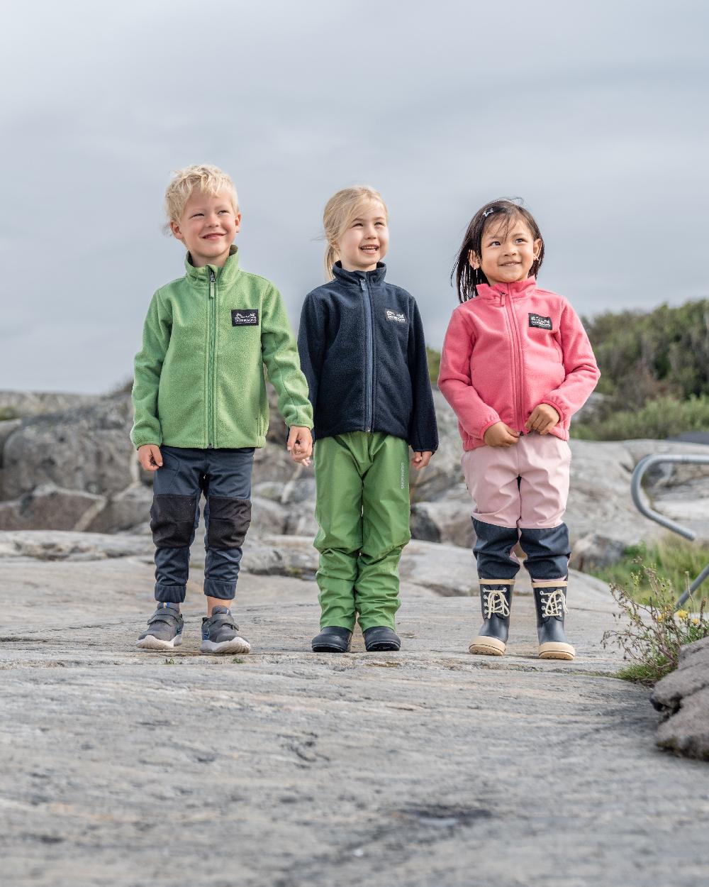Algae Green coloured Didriksons Childrens Muskot Jacket on coastal background 
