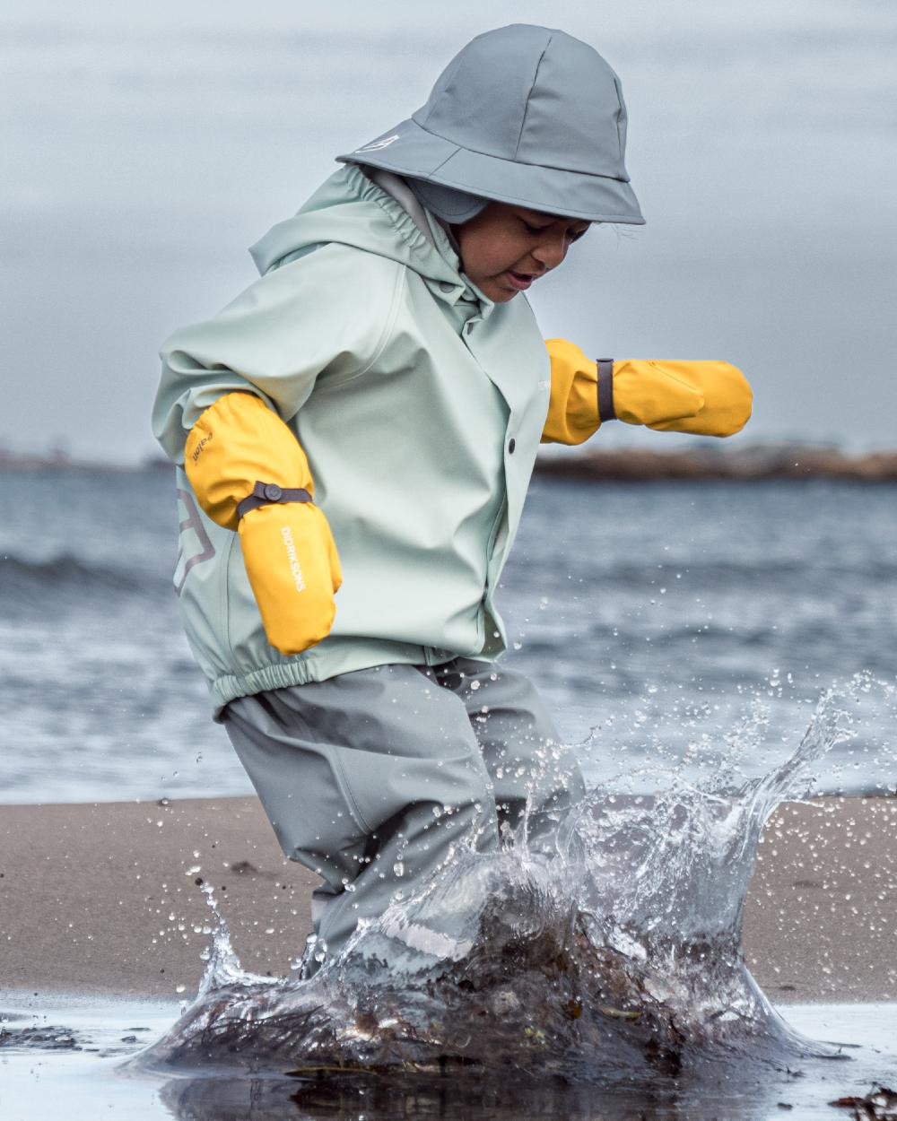 Ocean Mint coloured Didriksons Childrens Slaskeman Rain Set 2 on sea background 