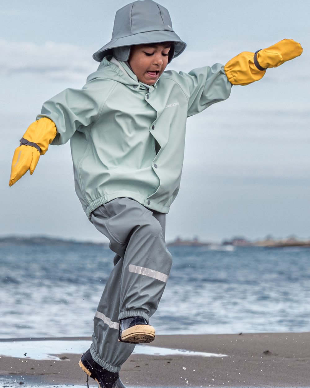 Ocean Mint coloured Didriksons Childrens Slaskeman Rain Set 2 on sea background 
