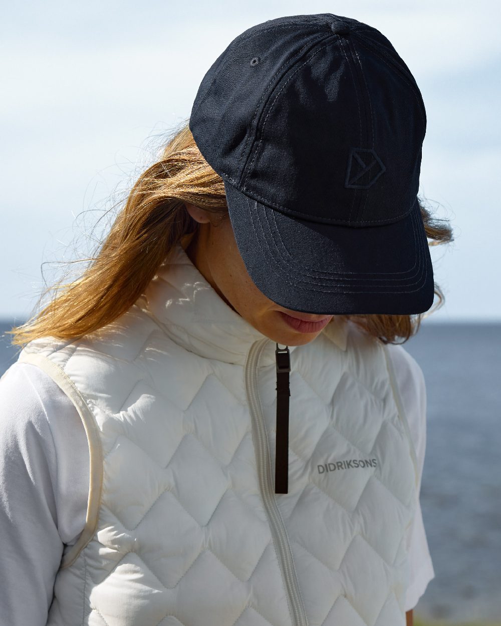 Dark Night Blue coloured Didriksons Derin Cap 2 on sea background 