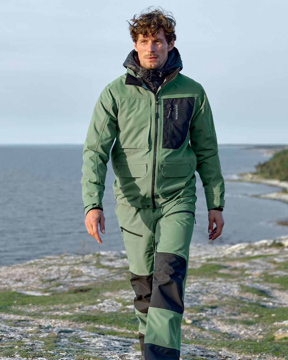 Dark Moss coloured Didriksons Fractus Waterproof Jacket on sea background 