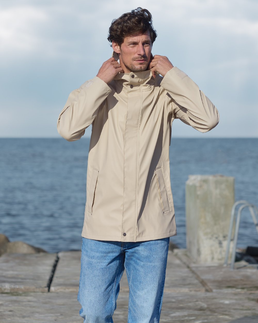 Clay Beige coloured Didriksons Mens Darwin Jacket on sea background 