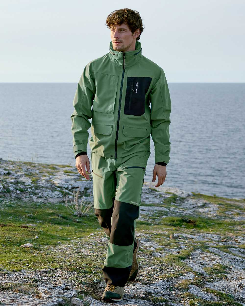 Dark Moss coloured Didriksons Mens Fractus Pants on sea background 